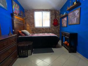 a bedroom with a bed and a blue wall at Cómoda habitación para descanso, La casa del artista in Toluca