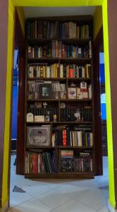 a book shelf filled with lots of books at Cómoda habitación para descanso, La casa del artista in Toluca