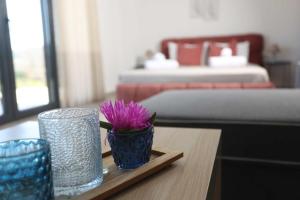 a table with two blue vases and a purple flower at Hilltop Apartment 6 in Hanioti