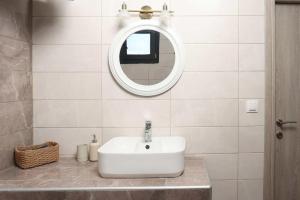 a bathroom with a white sink and a mirror at Hilltop Apartment 6 in Hanioti +10 photos