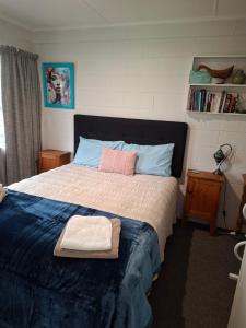 a bedroom with a bed with a towel on it at Bach on Waikawa 2 bedroom home in Picton