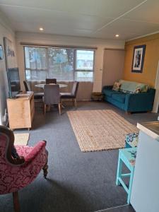 a living room with a couch and a table at Bach on Waikawa 2 bedroom home in Picton