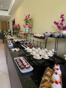 ein Buffet mit vielen verschiedenen Kuchen- und Gebäcksorten in der Unterkunft Summit Rainforest Golf Resort & All Inclusive in Panama-Stadt