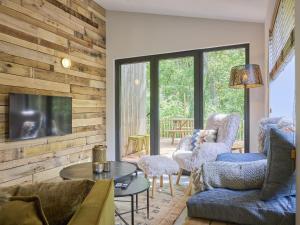 a living room with a couch and chairs and a tv at Cabin 22 in Zutendaal