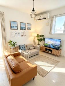 a living room with a couch and a tv at Nan Hotel Osaka in Osaka