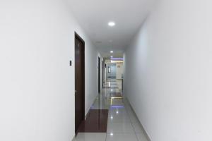 a corridor of a hospital with white walls and a door at Collection O Mythri Hotel Near By ECIL, AS RAO Nagar, Sainikpuri in Hyderabad