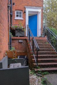 a set of stairs with a blue door on a brick building at Two Perfect for large groups and secured free parking in Reading
