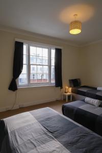 a hotel room with two beds and a window at Two Perfect for large groups and secured free parking in Reading