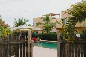 a fence with a pool in front of a building at Cerritos Surf Residences in El Pescadero