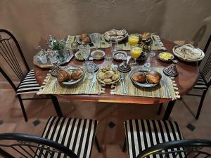 a wooden table with food and drinks on it at Riad Dar khadija in Taroudant