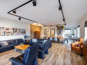 a living room with blue couches and a table at Villa Kaagervaaring in Kaag