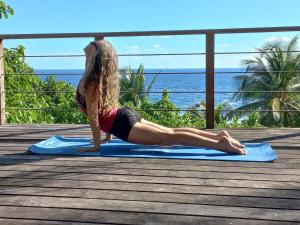 a woman doing a yoga pose on a yoga mat on a deck at The Pool House in Saint Philip