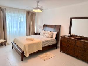 a bedroom with a bed and a dresser and a mirror at Palm Paradise Condo Pool & Beach in Punta Cana