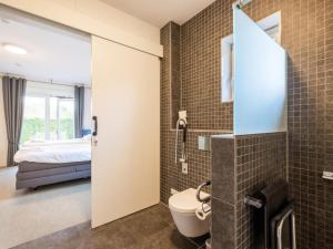 a bathroom with a toilet and a bed in a room at Villa Kaagervaaring in Kaag +49 photos