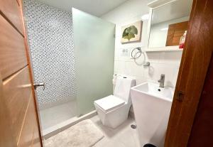 a small bathroom with a toilet and a sink at Palm Paradise Condo Pool & Beach in Punta Cana +11 photos