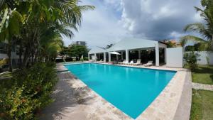 a large blue swimming pool with palm trees at Palm Paradise Condo Pool & Beach in Punta Cana