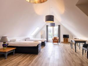 a attic bedroom with two beds and a table at Villa Kaagervaaring in Kaag