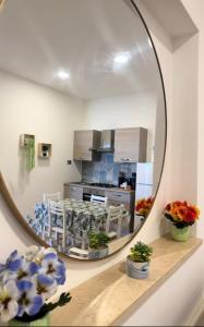 a mirror in a kitchen with flowers on a shelf at Vista mare Fiumicino-Beach&Fly Stay in Fiumicino