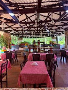 a restaurant with tables and chairs with pink table cloth at Hotel TIERRA NUEVA Campestre in La Vega