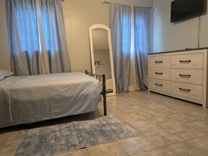 a bedroom with a bed and a dresser and a mirror at Cottage & Garden in Jacksonville