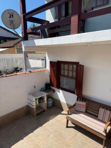 a patio with a bench and a table on a building at APARTAMENTO SIMPLES E ACONCHEGANTE in Paraty