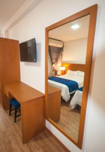 a mirror in a hotel room with a bed and a desk at Hotel Jardin in San Cristóbal