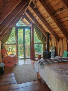 a bedroom with a bed and a large window at DondeLalo Hospedaje y Camping in Heredia