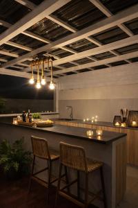 a kitchen with a bar with two chairs and a counter at Fairview Holiday Villa in Rivière Noire +1 photo
