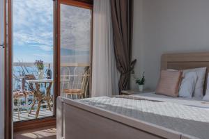 a bedroom with a bed and a balcony with a table at Apartments Pietra Mare in Petrovac na Moru