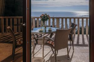 a table and chairs on a balcony with the ocean at Apartments Pietra Mare in Petrovac na Moru