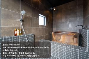 a bathroom with a shower with a copper tub at Soubou Otaru in Otaru