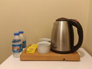 a tea kettle on a cutting board next to bottles of water at Taxim in Istanbul