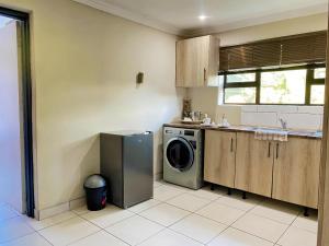 a kitchen with a dishwasher and a washing machine at Modern Luxe Escape in Kempton Park