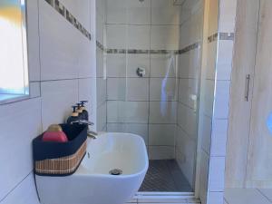 a white bathroom with a shower and a sink at Modern Luxe Escape in Kempton Park