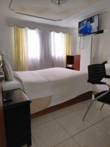 a bedroom with a large bed with a tv on the wall at La Gran Fortaleza B&B in Bogotá