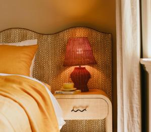 a red lamp on a night stand next to a bed at Sona Molong in Molong