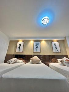 a bedroom with two beds with pictures of birds on the wall at Hotel Lesus in Medellín