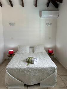 a bedroom with a white bed with two pillows at Villa Dulce Caliente au Vauclin in Le Vauclin
