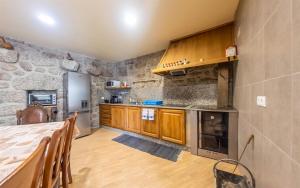 a kitchen with wooden cabinets and a stone wall at Casa da Bia - Gerês in Terras de Bouro