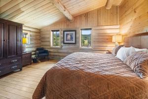 a bedroom with a bed in a room with wooden walls at Trappers Cabin in Beaver Creek