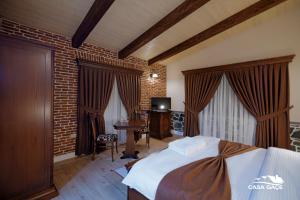 a bedroom with a bed and a desk and a television at Casa Gaçe Hotel in Korçë