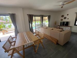 a living room with a couch and a table at Villa Sabaï • Private Pool • Thong Krut in Nathon Bay