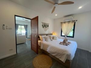 a bedroom with a bed and a ceiling fan at Villa Sabaï • Private Pool • Thong Krut in Nathon Bay +9 photos