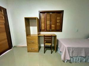 a bedroom with a desk and a bed and a dresser at Pousada Chale Joana in Alter do Chao +11 photos