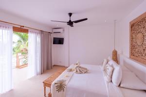 a white bedroom with a bed and a couch at Bukit Adi in Amed +51 photos