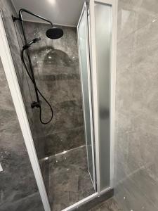 a shower with a glass door in a bathroom at Váš domov v Kruškách in Rotava