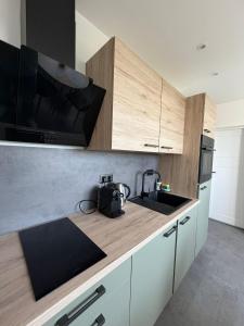 a kitchen with a counter with a sink and a microwave at Váš domov v Kruškách in Rotava +6 photos