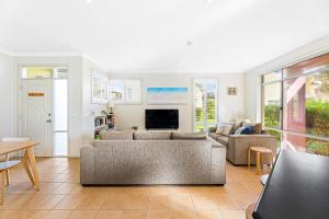a living room with a couch and a table at Bec's Beach House Getaway in Batemans Bay +19 photos