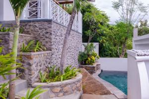 a villa with a swimming pool and a house at Bukit Adi in Amed