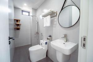a white bathroom with a sink and a mirror at Cát Boutique Hotel in Dong Hoi